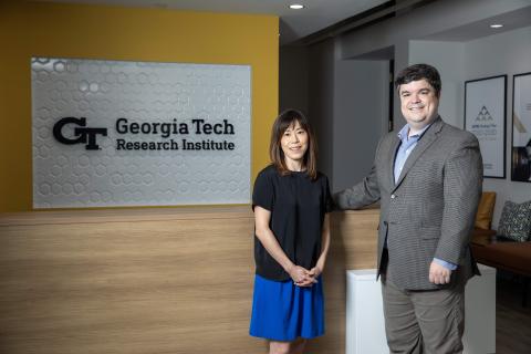 A photo of two GTRI researchers standing in front of a GTRI sign. 