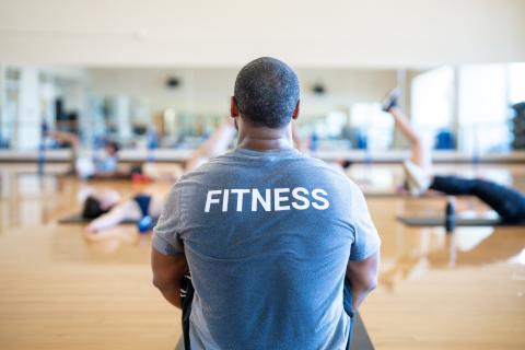 person wearing grey tshirt with text fitness printed. 