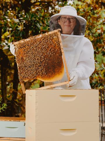 Woman standing with a honeycomb.
