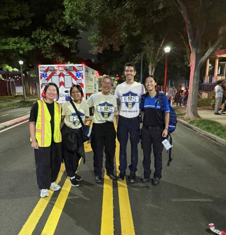 Students stand in front of an ambulance.