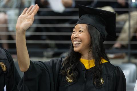 Georgia Tech student waives at commencement ceremony.