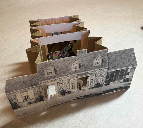 Expanded tunnel book; its cover is an image of a black-and-white house with open doors and windows. 