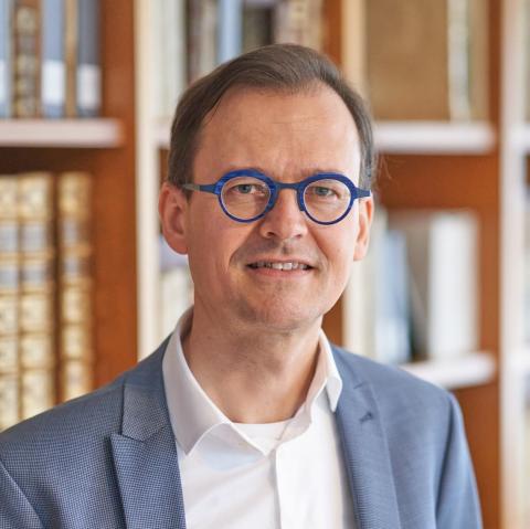 Headshot photo of Dr. Joran Proot, a man with short brown hair and circular blue glasses. 