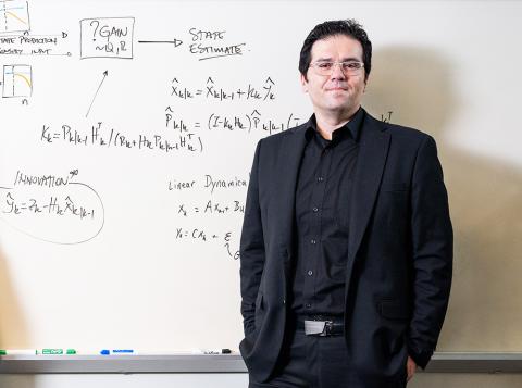 Tansu Celikel standing in front of dry erase board