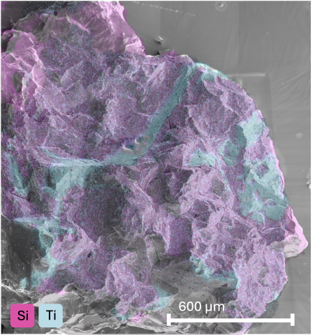 The sample chip imaged using scanning electron microscopy. There are swaths of purple and lines of blue.