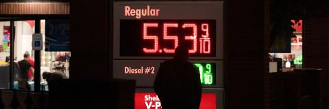 Gas Prices on Electronic Display with the gas station convenience store in the background at night