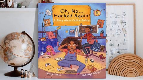 A copy of Oh, No...Hacked Again!: A Story About Online Safety stood up on a desk covered in children's toys.