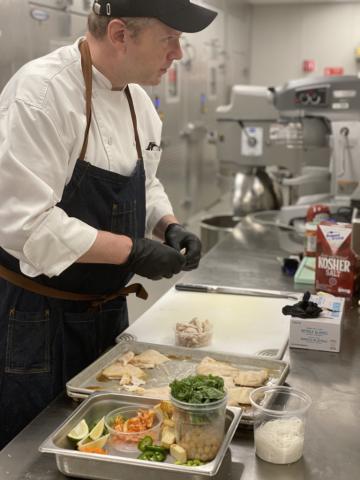 Photo of Tech Dining Director of Culinary Scott Bruhn preparing food in a kitchen.