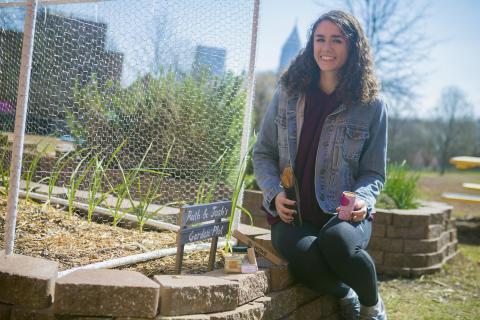 Clare Trively sits the community garden.