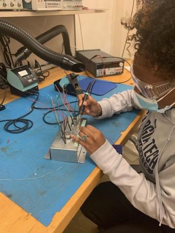 Breanna Ivey works on the front panel electronics for the incubator.