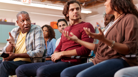 Stock photo of people having a discussion at a neighborhood meeting