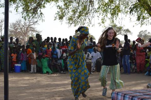 Tech student Lane McAree learns a traditional dance from a Senegalese woman in Sass Mack-Satem.