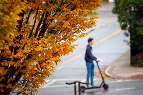 Student Rides a Scooter on Campus