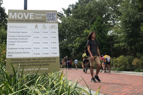 Image of students walking on campus next to a Move Georgia Tech yard sign.