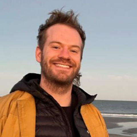 Headshot of Ben Wills in front of the ocean