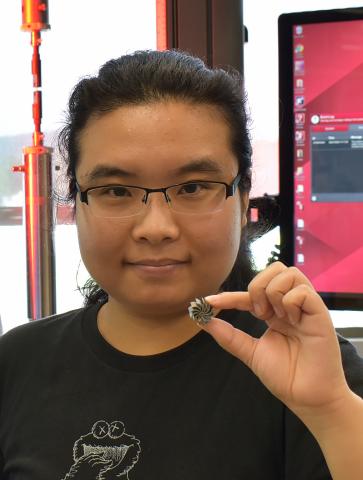 UMass Amherst Ph.D. student Jie Ren holds a miniature heatsink fan