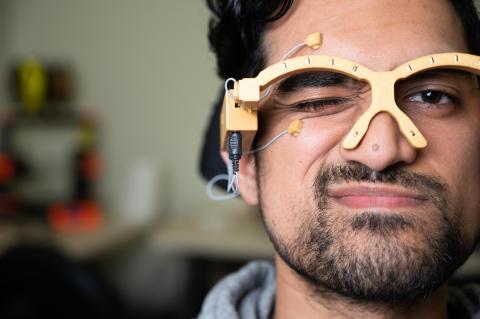 man squinting wearing wheelchair controlling headgear 