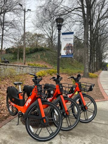 Photo of e-bikes stationed next to Georgia Tech campus sidewalk.