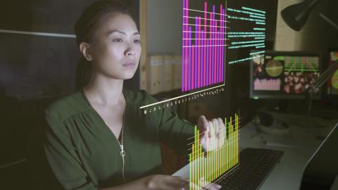 Woman interacting with screen of graphs and data