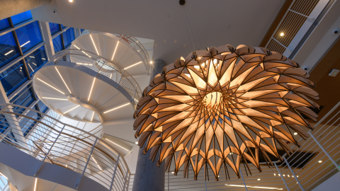 Interior of the CODA Tech Square building with a spiral staircase and ornate lamp fixture