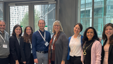 A group of students and faculty pose together at the REvaluation Conference in Vienna, Austria.