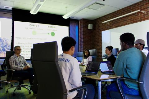 Anton Bryskin (far left) sits with Sanger's web development team to discuss the program's website structure.