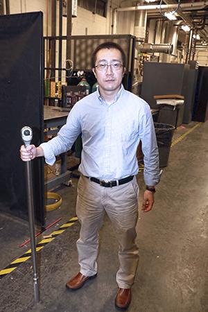 Dr. Wenting Sun is seen here with a three-foot long, 15-pound wrench, used to maintain the $500K shock tube now in his lab