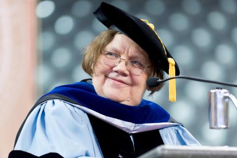 Close-up of Dr. Susan Cozzens at speakers podium in full academic regalia