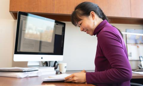 Iris Tien looks at documents at her desk