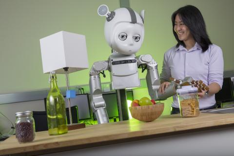 Vivian Chu poses with the robot Curi, which she works with in her lab.