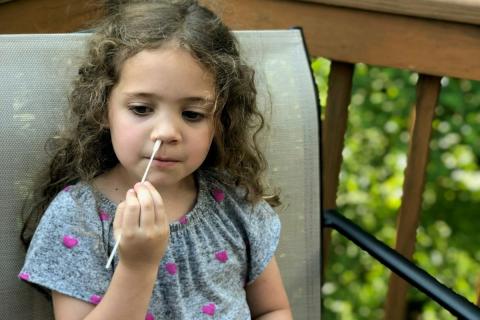A child swabs their nose for Covid-19 testing.