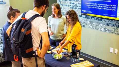 Dietitians talk to students while preparing a snack