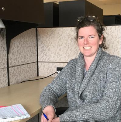 Photo of Sarah Barnes sitting at a desk, smiling