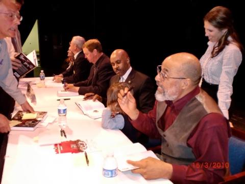 Ron Johnson (seated third from left) talking with his five-year-old godson, Eli Easley, at a Wilmington, North Carolina, book panel. Standing is Eli's mohter, Tara Easley (Mrs Hawaii International 2002).