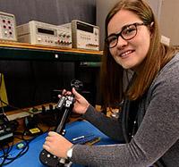 Electrical engineering major Amanda Remus holds a leg brace from the Smart Wheelchair.