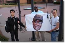 Students Qining Sun, Tyrone Wells and Michael Roy prepare to hoist Major’s flag