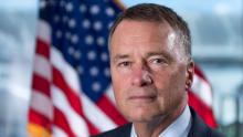 Headshot of Adm. James “Sandy” Winnefeld in front of an American flag.