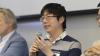 A photo of Victor Fung, an assistant professor with Georgia Tech’s School of Computational Science and Engineering (CSE), seated between men holding a microphone 