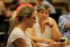 Faculty sit at tables during the Course Design Studio reflecting on their course design materials.