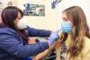 Female student getting flu shot from female nurse