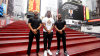 Antwan Owens posing with two men from the company that endorsed him in front of a sign in Times Square about the deal.