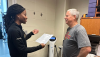 A female personal trainer talks to a male participant about body scan results