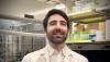 Headshot of Christos Athanasiou in his lab, wearing a white collared shirt and white lab coat