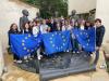 Group photo with three holding the EU flag.