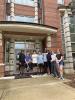 Students stand in front of a brick dormitory.