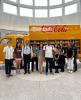 Students standing in front of Coca-Cola yellow delivery truck.