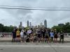 FYSA students stand in front of Atlanta skyline in bike helmets.