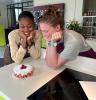 Two girls stare at a strawberry cake