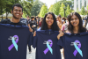 Students holding shirts and smiling