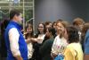 Man in blue vest speaks with students.